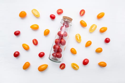 Red and yellow cherry tomatoes on a white background, up view