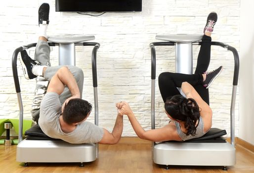 Young woman and men exercise together in gym