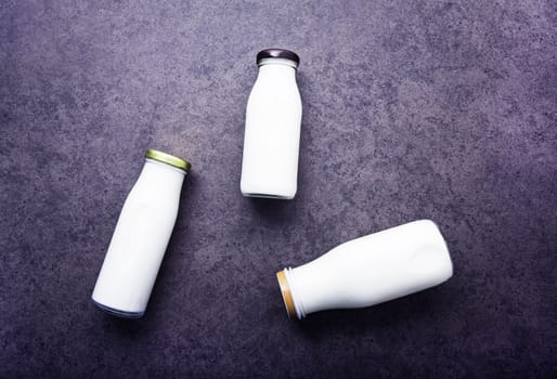 Milk bottle on dark stone background. Top view with copy space.