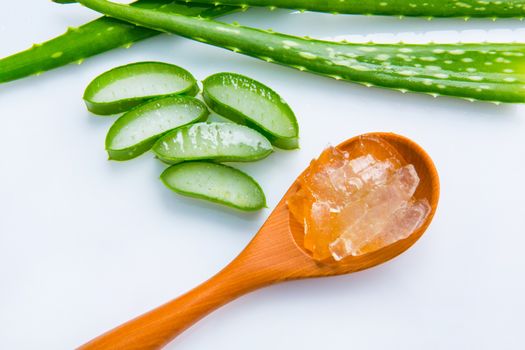 Aloe vera fresh leaves with slices and aloe vera gel on wooden spoon. isolated over white