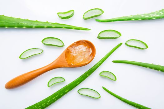 Aloe vera fresh leaves with slices and aloe vera gel on wooden spoon. isolated over white