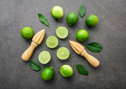 Fresh limes and wooden juicer on white background. Top view with copy space