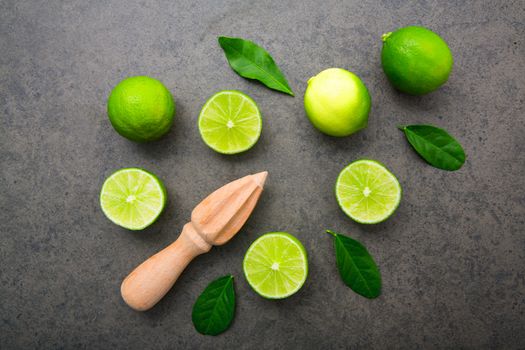 Fresh limes and wooden juicer on white background. Top view with copy space