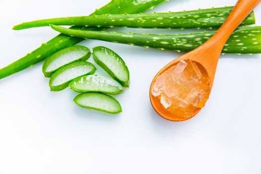 Aloe vera fresh leaves with slices and aloe vera gel on wooden spoon. isolated over white