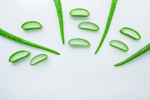 Aloe vera fresh leaves with slices aloe vera gel on wooden spoon. isolated over white 