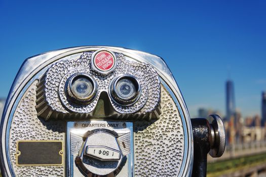 Close up of coin operated binoculars with New York City skyline in background