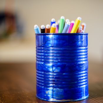 blue pen holder recycled from a tin box for preserves with colored markers