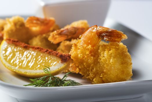 Crispy prawns with lemon slice on plate