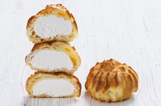 Profiteroles on plate on a table on wooden background