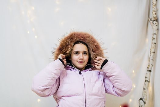 portrait of teenager in studio with pink winter jacket with fur hood