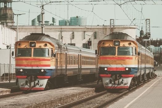 Old yellow passenger diesel train moving at the terminal