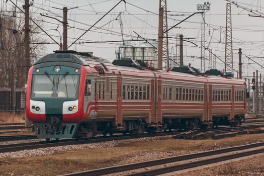 Red diesel passenger train driving at the old terminal