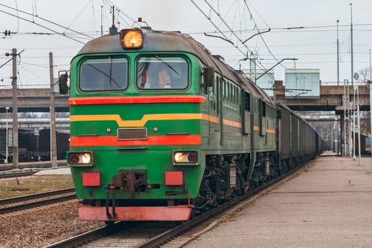 Green diesel cargo locomotive. Freight train in action