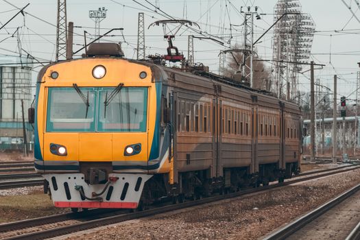 Yellow modern passenger electric train moving at the old terminal