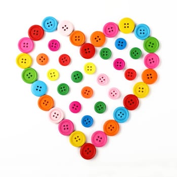 Heart shaped of colorful multicolor round painted wooden handmade sewing buttons isolated on white, close up, elevated top view