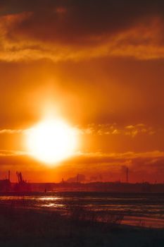 Hot orange winter sunrise against the cargo port