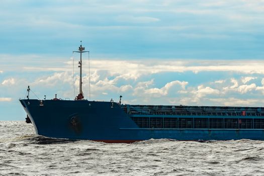 Merchandise import. Large blue cargo ship moving to Riga port