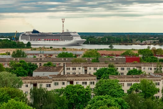 Big white cruise liner sailing past the cargo port