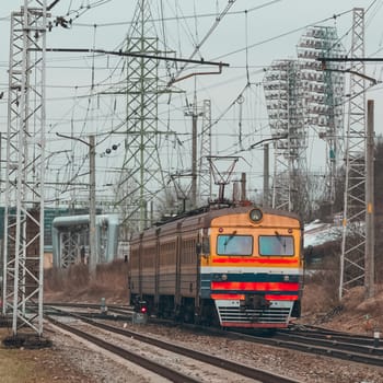 Old yellow passenger electric train driving at the terminal