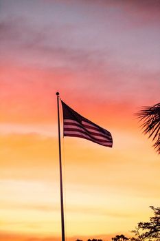 Red, white and blue American flag blows in the wind  at sunrise