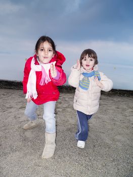 Children playing on the beach in winter, Lake Maggiore, Ispra, Lombardy, Italy