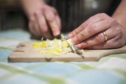 woman's hands with ring cut vegetables on the kitchen cutting board