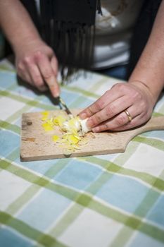 woman's hands with ring cut vegetables on the kitchen cutting board