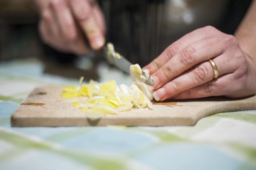 woman's hands with ring cut vegetables on the kitchen cutting board