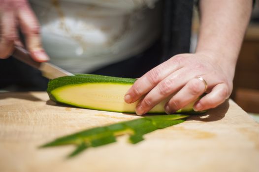 woman's hands with zucchini-cut ring on the kitchen cutting board to prepare dinner or lunch