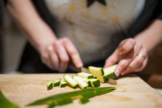 woman's hands with zucchini-cut ring on the kitchen cutting board to prepare dinner or lunch