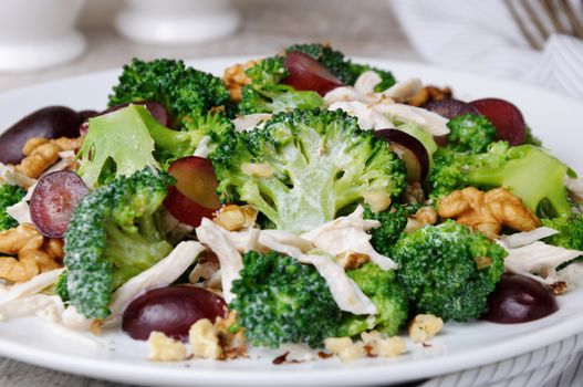 Dietary broccoli salad with chicken, sliced grapes, crushed nuts and yoghurt dressing