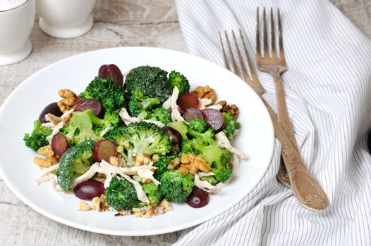 Dietary broccoli salad with chicken, sliced grapes, crushed nuts and yoghurt dressing