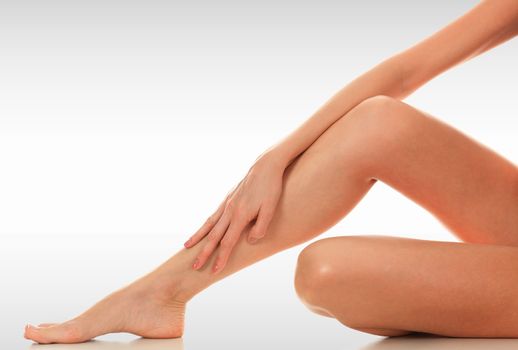 Closeup shot of beautiful female legs and hands. Unwanted hair removal concept