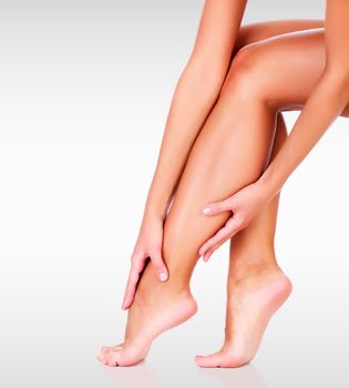 Closeup shot of beautiful female legs and hands. Unwanted hair removal concept. Perfect smooth skin