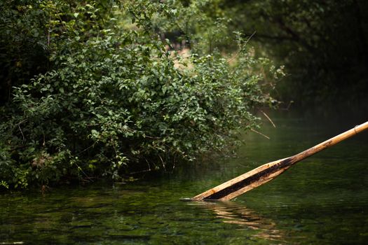 old wooden paddle (oar) from a row boat in a misty water