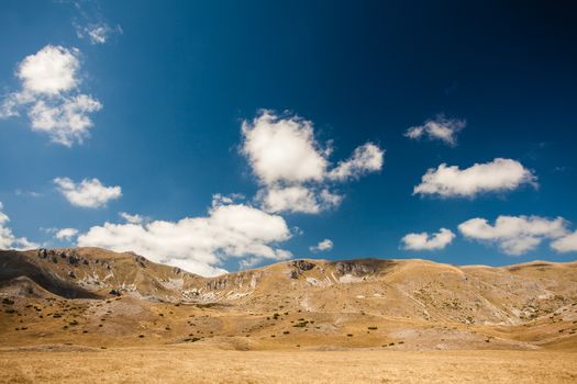 nature scenery in autumn, field with mountains in the background