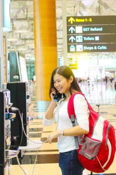 pretty traveller making a phone call at airport 