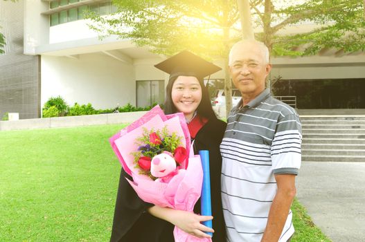 Asian university student and father celebrating graduation outdoor