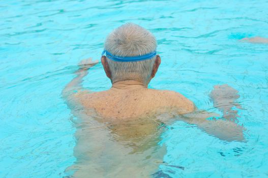 back of senior man on the side of swimming pool