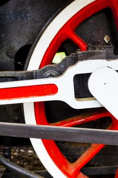 red and white wheel of an old historic steam train on rail