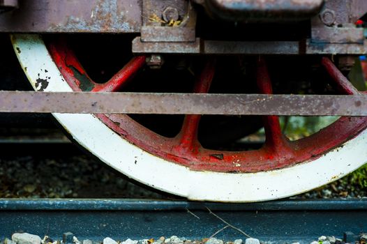 red and white wheel of an old historic steam train on rail