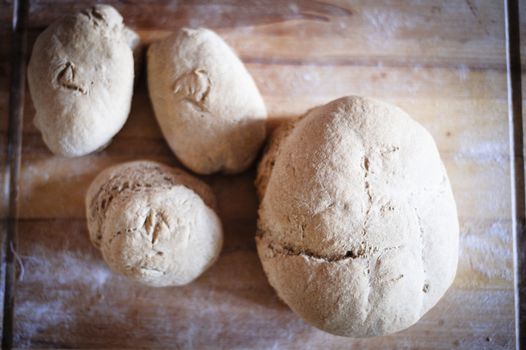 Homemade whole wheat bread with organic sourdough, wooden background