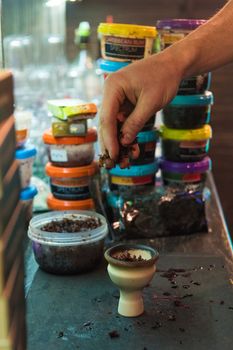 Shisha hookah preparing by barman. Bartender lays tobacco for smoking in hookah