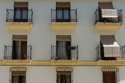 Blinds on a window on a house in the street in the city of Ronda Spain, Europe on a hot summer day with clear blue skies