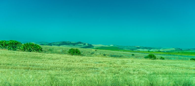 Greenery, Mountains, Farms and Fields on the outskirts of Ronda Spain, Europe on a hot summer day with clear blue skies