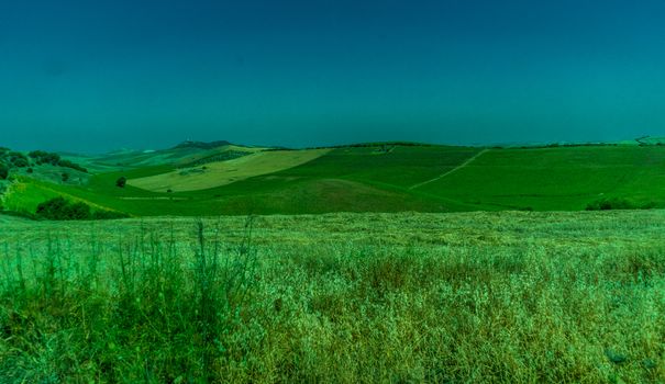 Greenery, Mountains, Farms and Fields on the outskirts of Ronda Spain, Europe on a hot summer day with clear blue skies