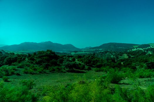 Greenery, Mountains, Farms and Fields on the outskirts of Ronda Spain, Europe on a hot summer day with clear blue skies