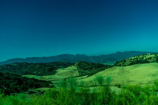 Greenery, Mountains, Farms and Fields on the outskirts of Ronda Spain, Europe on a hot summer day with clear blue skies