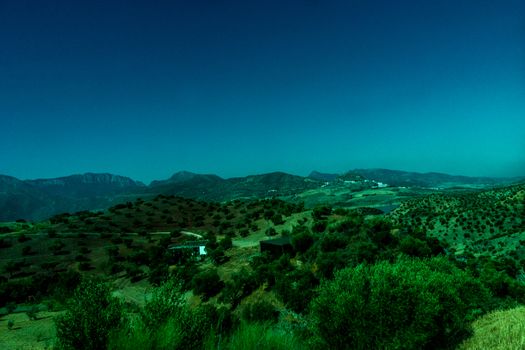 Greenery, Mountains, Farms and Fields on the outskirts of Ronda Spain, Europe on a hot summer day with clear blue skies