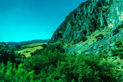 Greenery, Mountains, Farms and Fields on the outskirts of Ronda Spain, Europe on a hot summer day with clear blue skies